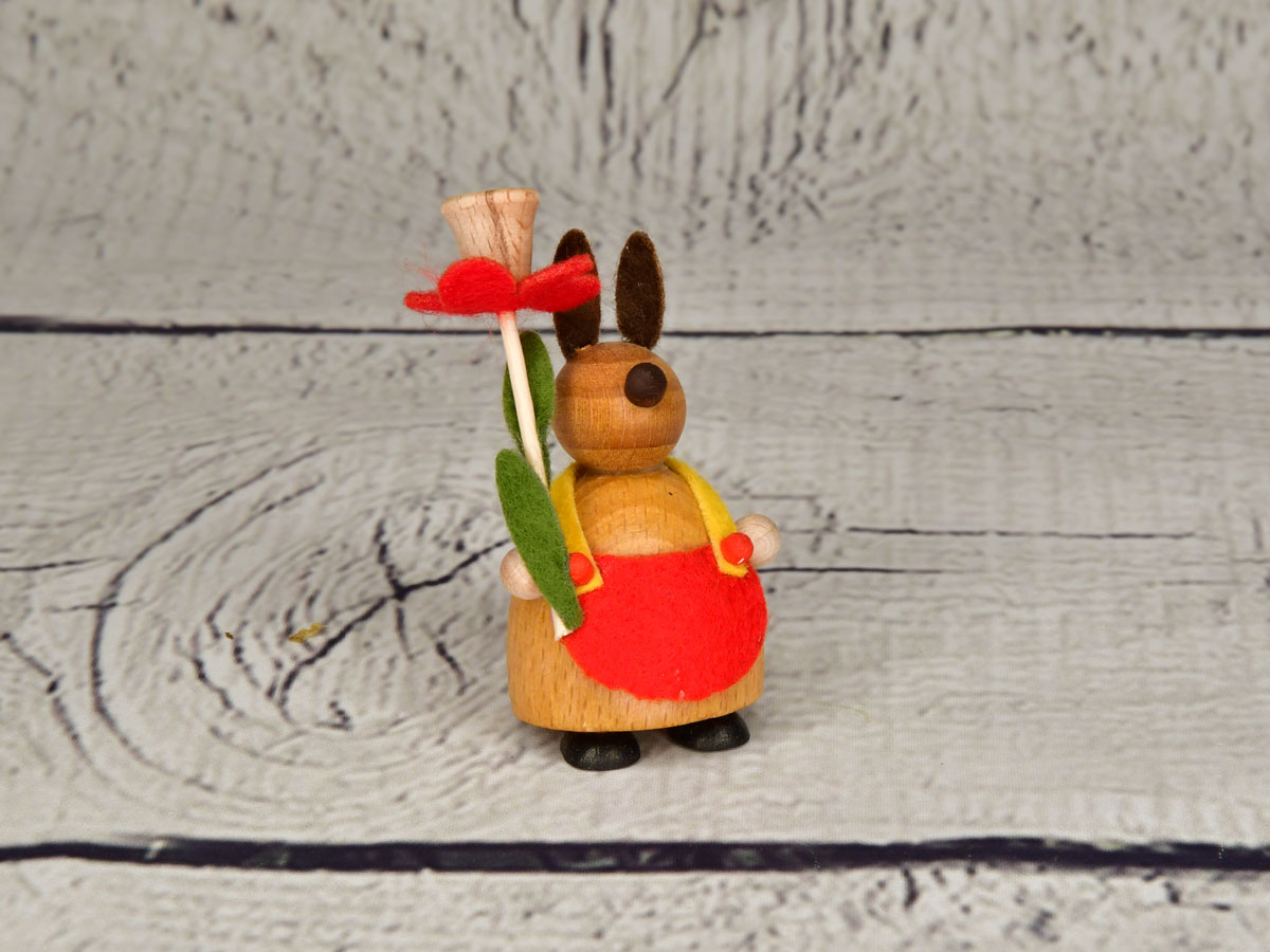 Pupu punaisella/luonnonvärisellä kukalla, punainen esiliina