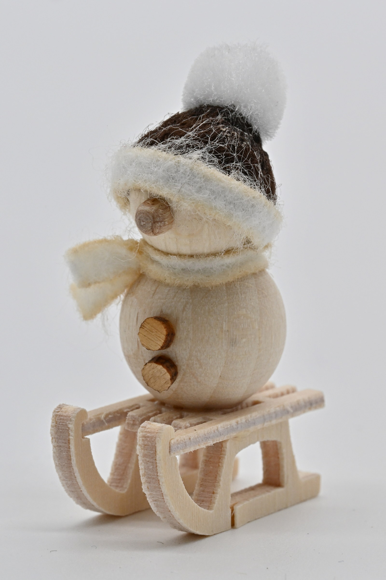 Schneemann natur, auf Schlitten braune Mütze