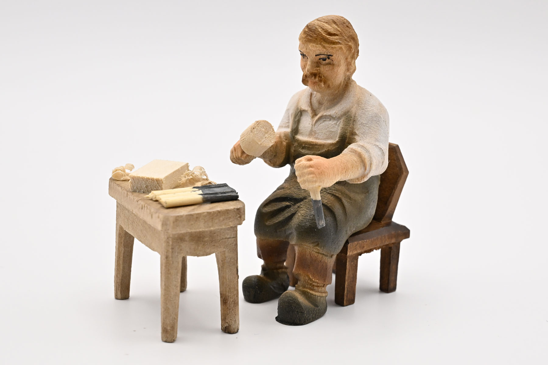 Woodcarver, seated, coloured 50 x 85 mm