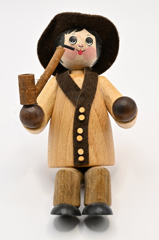 Large figure, man with hat and pipe, seated